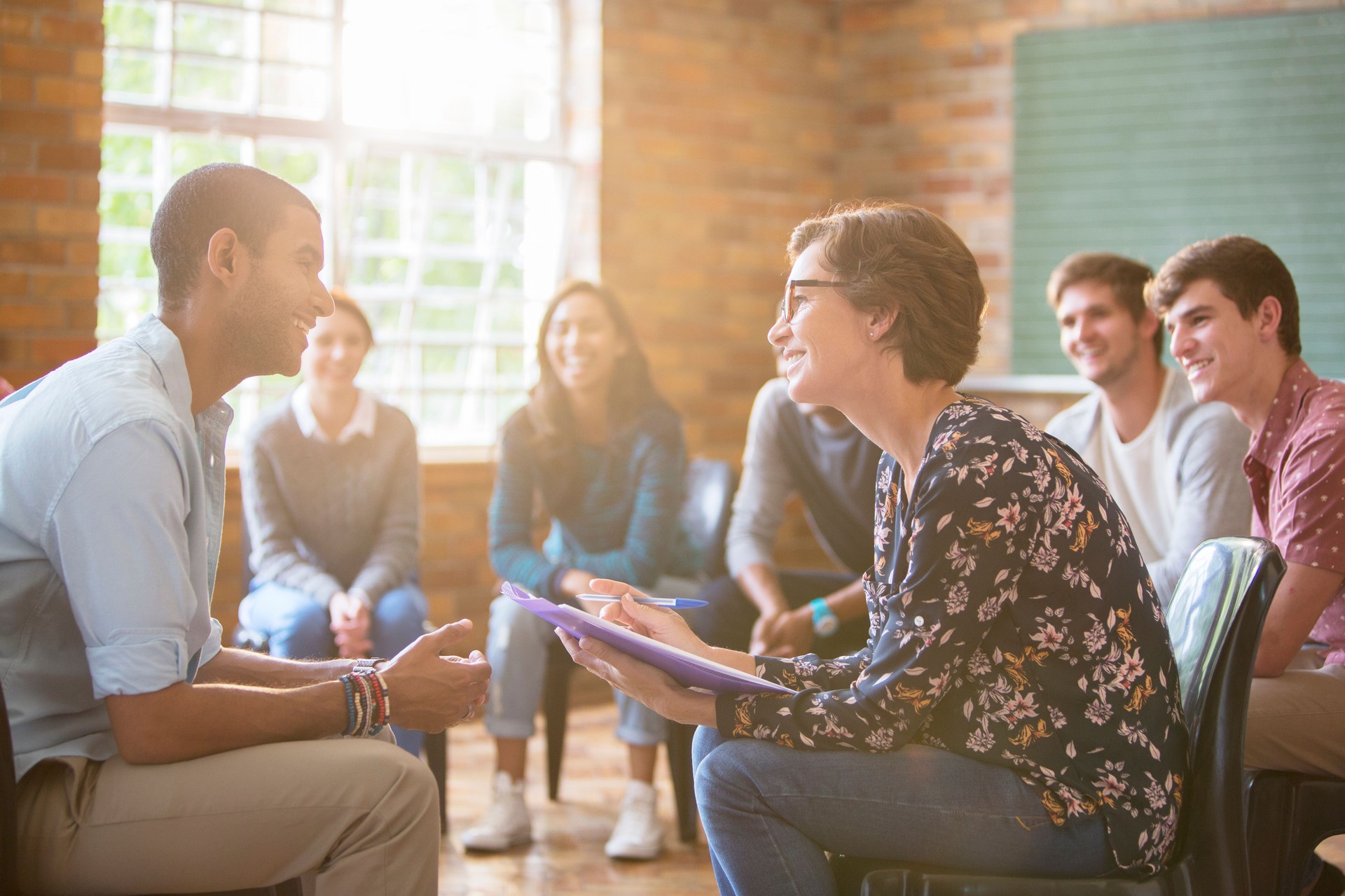 Group watching man and woman talking in group therapy session